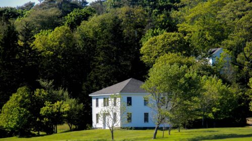 Charming White Colonial House Surrounded by Lush Summer Forest Desktop Wallpaper