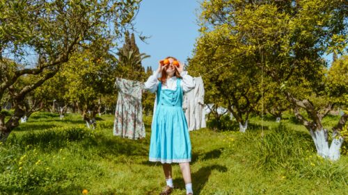 Whimsical Girl in Blue Dress with Oranges in Orchard 4K Desktop Wallpaper