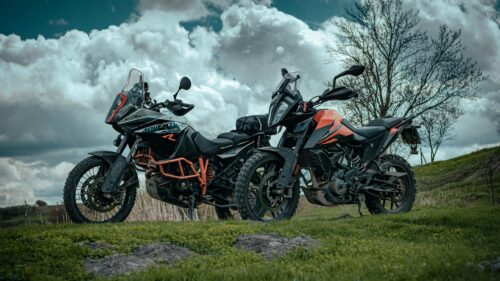 Two KTM Adventure Motorcycles Parked in a Grassy Field 4K Wallpaper