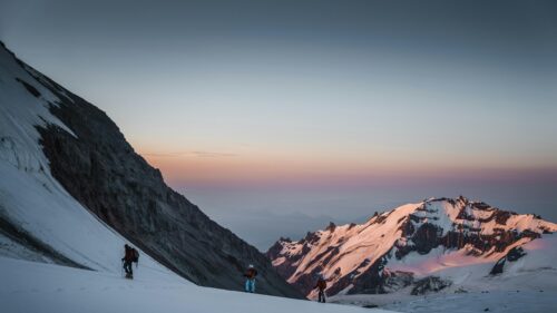 Mountaineers Climbing Snowy Mountain Peak at Sunset 4K Wallpaper