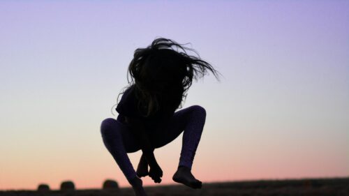 Silhouette of a Child Jumping at Sunset 4K Desktop Wallpaper