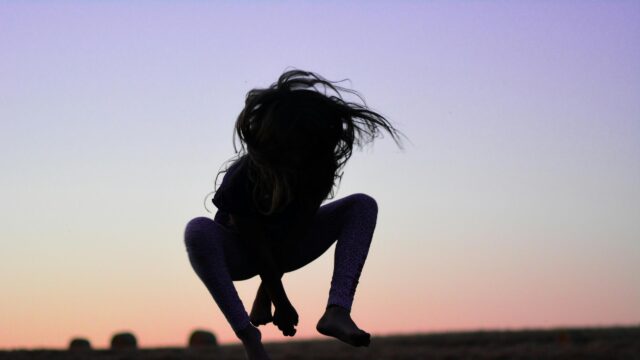 Silhouette of a Child Jumping at Sunset 4K Desktop Wallpaper