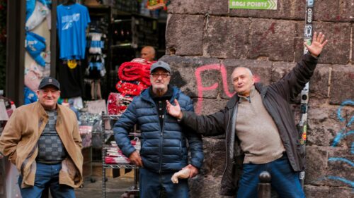 Three Cheerful Italian Men Standing on a Charming Street Desktop Wallpaper