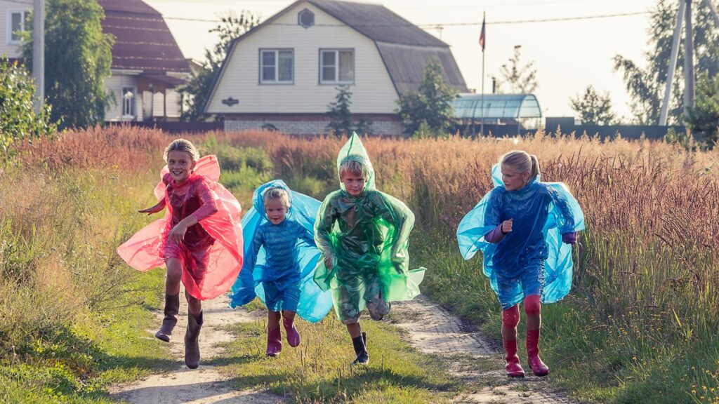 Happy Children Running in Colorful Raincoats Field Desktop Wallpaper