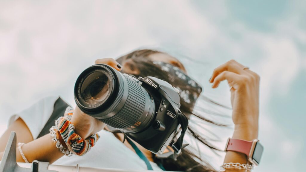 Woman Photographer Holding Nikon DSLR Camera Low Angle View Desktop Wallpaper
