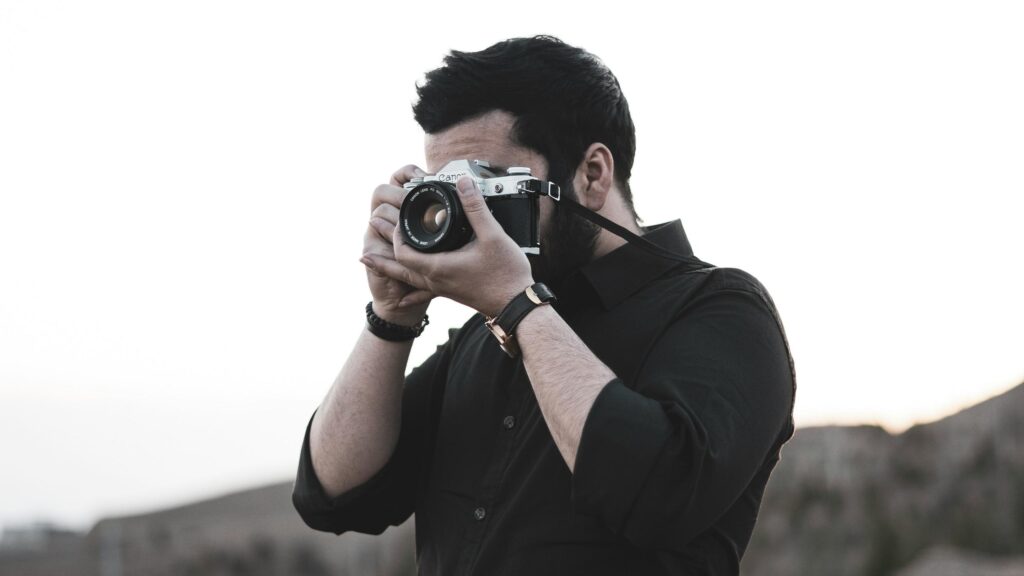 Professional Photographer Holding Vintage Canon Camera Desktop Wallpaper