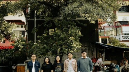 Group of Friends Standing Under a Tree in an Urban Setting Desktop Wallpaper