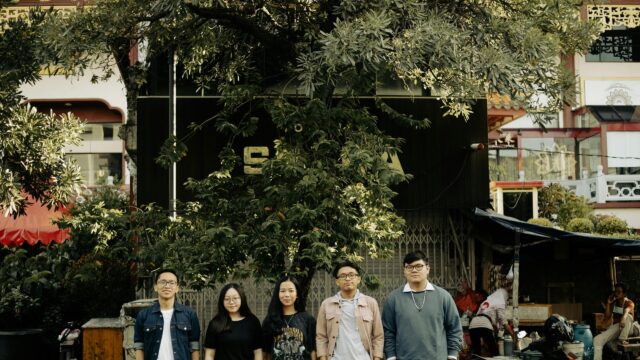 Group of Friends Standing Under a Tree in an Urban Setting Desktop Wallpaper
