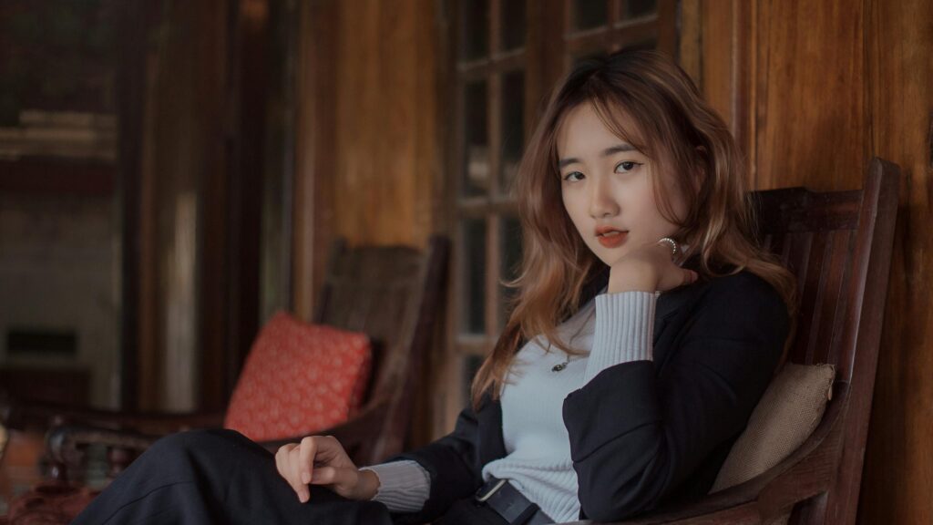 Elegant Asian Woman Sitting in Wooden Chair Desktop Wallpaper