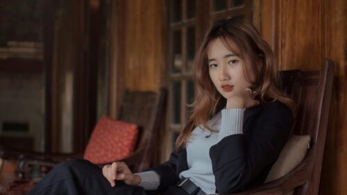 Elegant Asian Woman Sitting in Wooden Chair Desktop Wallpaper