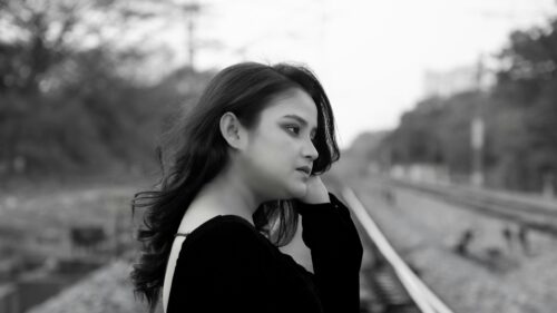 Sad Young Woman Standing on Railway Tracks Black and White Desktop Wallpaper