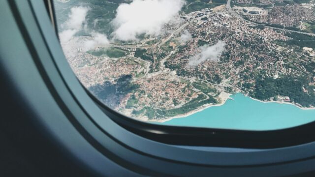 Aerial View of Coastal City from Airplane Window 4K Desktop Wallpaper