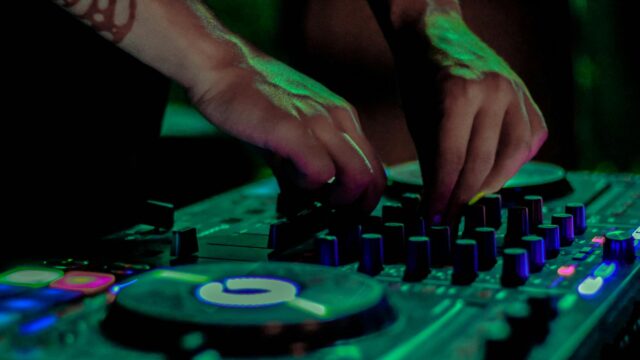 DJ Mixing Music on Controller Console 4K Desktop Wallpaper