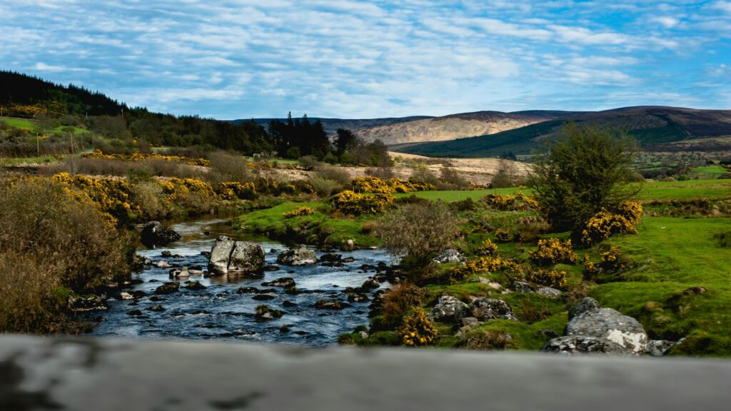 Serene Irish Countryside River Flowing Through Hills Desktop Wallpaper