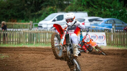 Motocross Rider Performing a Wheelie on Dirt Track Desktop Wallpaper
