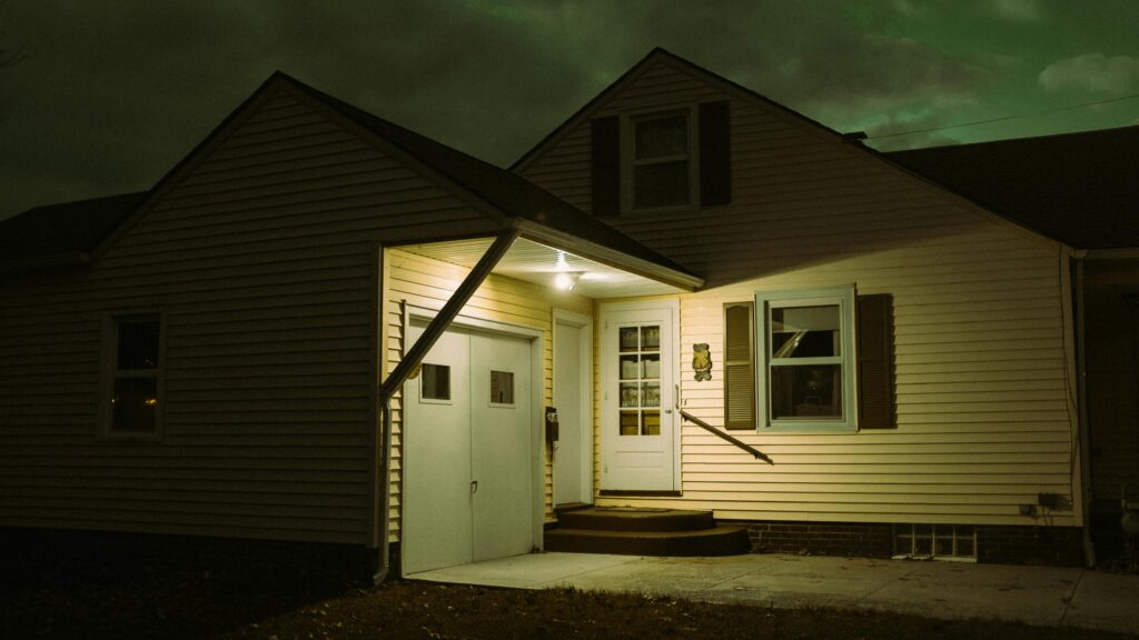 Eerie Suburban House at Night with Green Sky Desktop Wallpaper