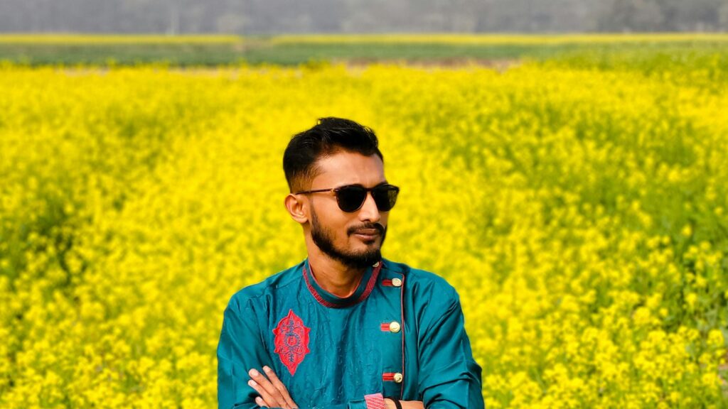 Young Man in Teal Ethnic Wear Standing in Mustard Field Desktop Wallpaper