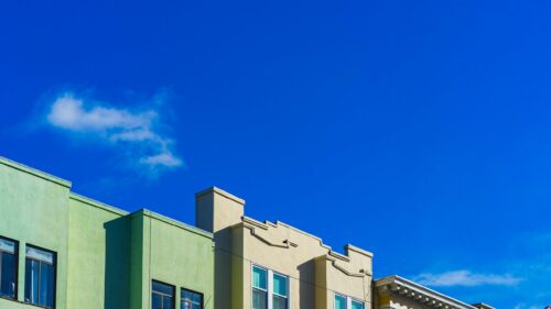 Minimalist Green and Beige Building Facades Under Clear Blue Sky 4K Wallpaper