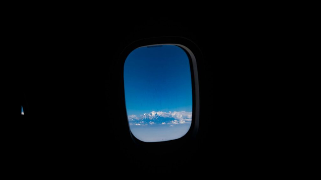 Snow-Capped Mountain Range Seen Through Airplane Window 4K Wallpaper