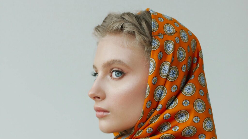 Elegant Young Woman in Vibrant Orange Floral Headscarf Desktop Wallpaper