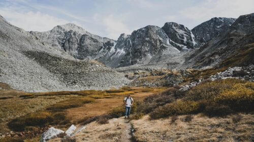 Hiker Exploring Rocky Mountain Valley Wilderness 4K Wallpaper