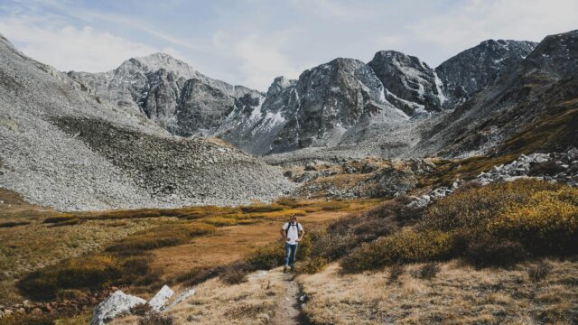 Hiker Exploring Rocky Mountain Valley Wilderness 4K Wallpaper