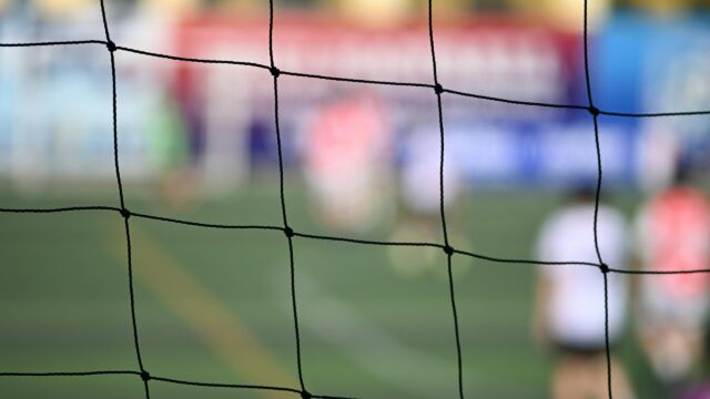 Blurred Soccer Pitch Through Goal Netting 4K Desktop Wallpaper