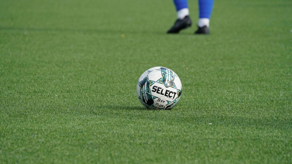 Select Football Ball on Green Grass Field 4K Wallpaper