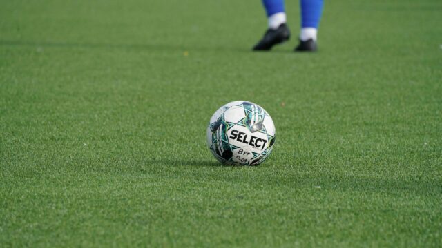 Select Football Ball on Green Grass Field 4K Wallpaper