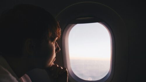 Pensive Traveler Looking Out Airplane Window 4K Desktop Wallpaper