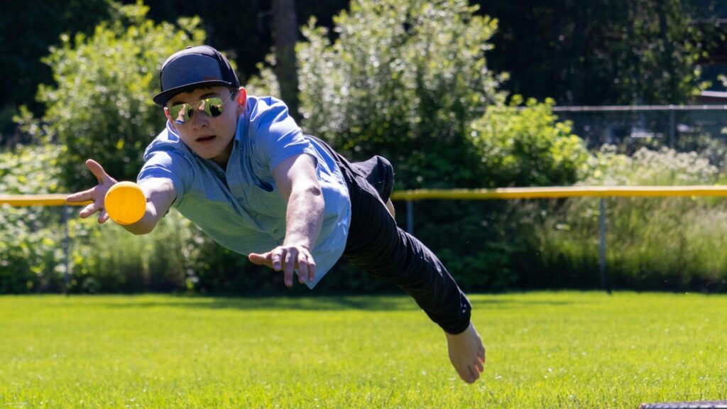 Young Boy Diving for a Ball in the Park 4K Wallpaper