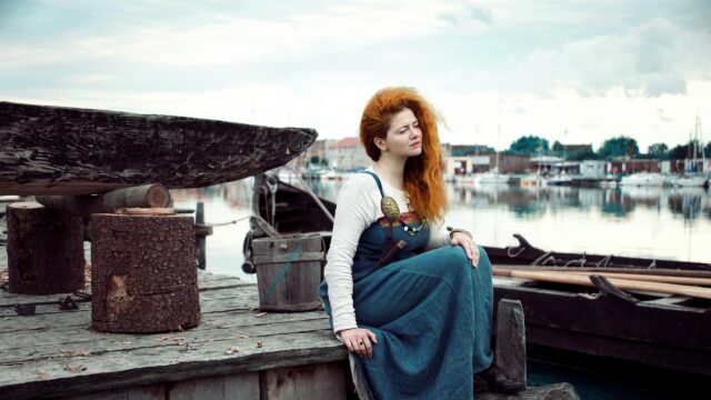 Red-Haired Viking Woman on Wooden Dock Desktop Wallpaper