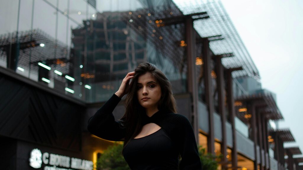 Stunning Portrait of a Brunette Woman in Stylish Black Outfit 4K Wallpaper
