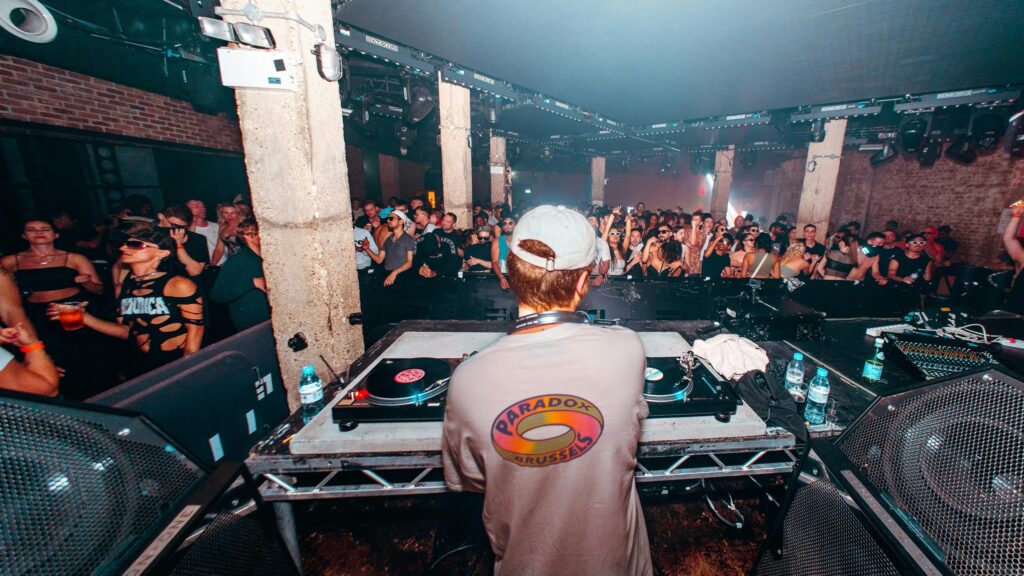 DJ Performing for an Electric Crowd at an Underground Nightclub 4K Wallpaper