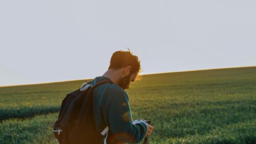 Man Photographing Golden Hour Meadow Desktop Wallpaper