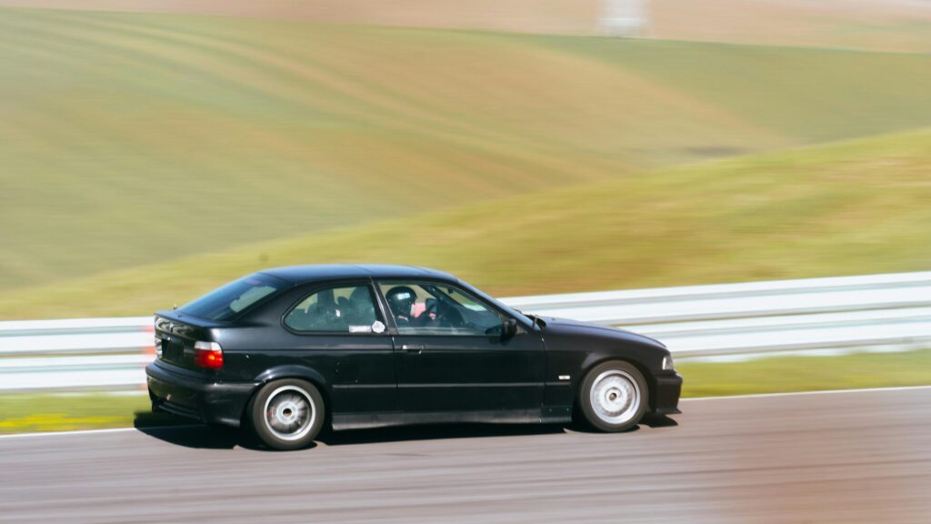 Black BMW E36 Compact Hatchback Racing on Track Desktop Wallpaper