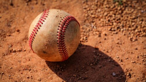Rugged Used Baseball on Red Clay Dirt 4K Wallpaper