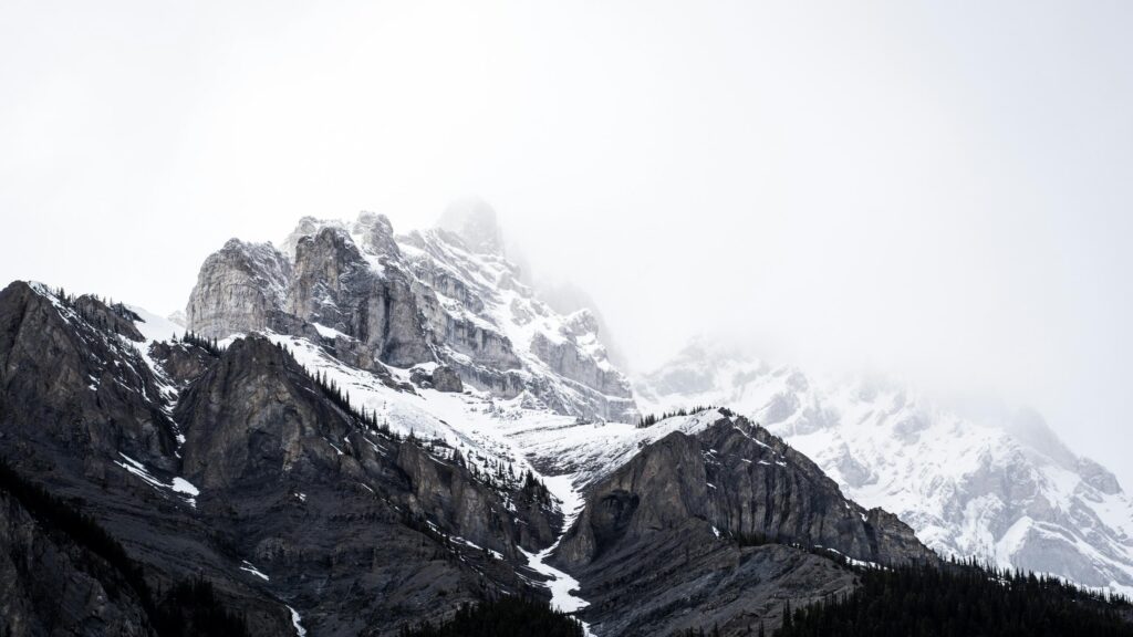 Majestic Snowy Peaks Covered in Mist 4K Desktop Wallpaper