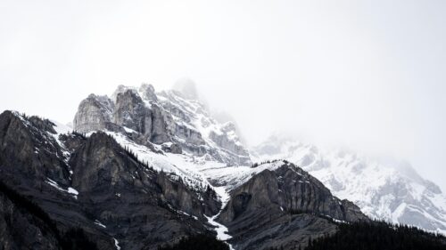 Majestic Snowy Peaks Covered in Mist 4K Desktop Wallpaper