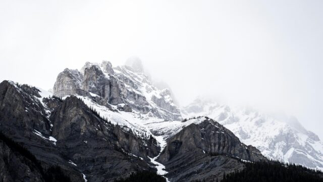 Majestic Snowy Peaks Covered in Mist 4K Desktop Wallpaper