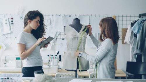 Fashion Designers Working in a Modern Sewing Studio 4K Wallpaper