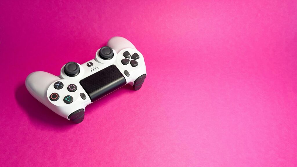 Minimalist White PlayStation Controller on Pink Background Desktop Wallpaper