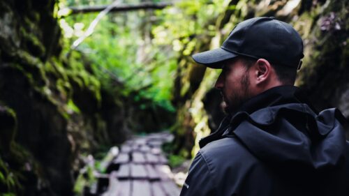 Man Exploring Lush Green Canyon Forest Adventure 4K Wallpaper
