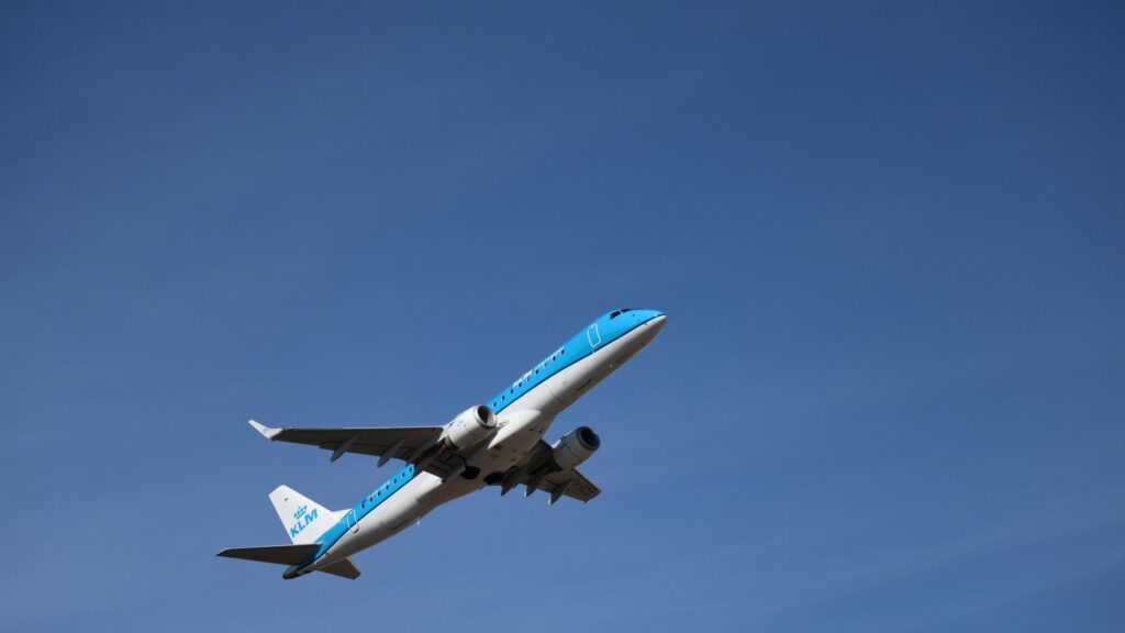 KLM Cityhopper Embraer E190 Passenger Jet Soaring in Clear Blue Sky 4K Wallpaper