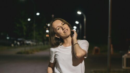 Young Woman Smiling Under Night Street Lights 4K Desktop Wallpaper