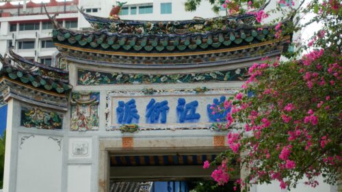 Ornate Traditional Chinese Temple Archway with Vibrant Pink Flowers Desktop Wallpaper