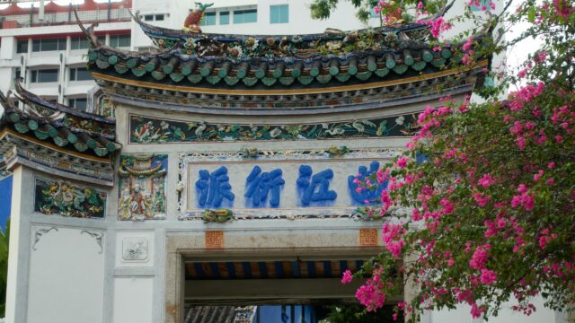 Ornate Traditional Chinese Temple Archway with Vibrant Pink Flowers Desktop Wallpaper