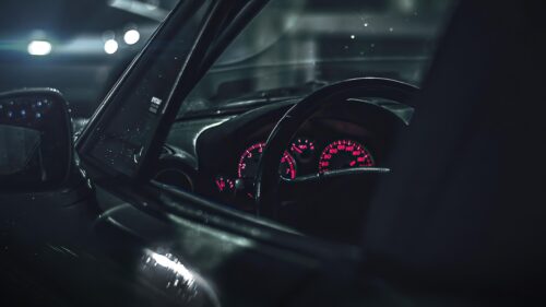 Atmospheric Car Interior Dashboard with Red Illuminated Gauges 4K Wallpaper