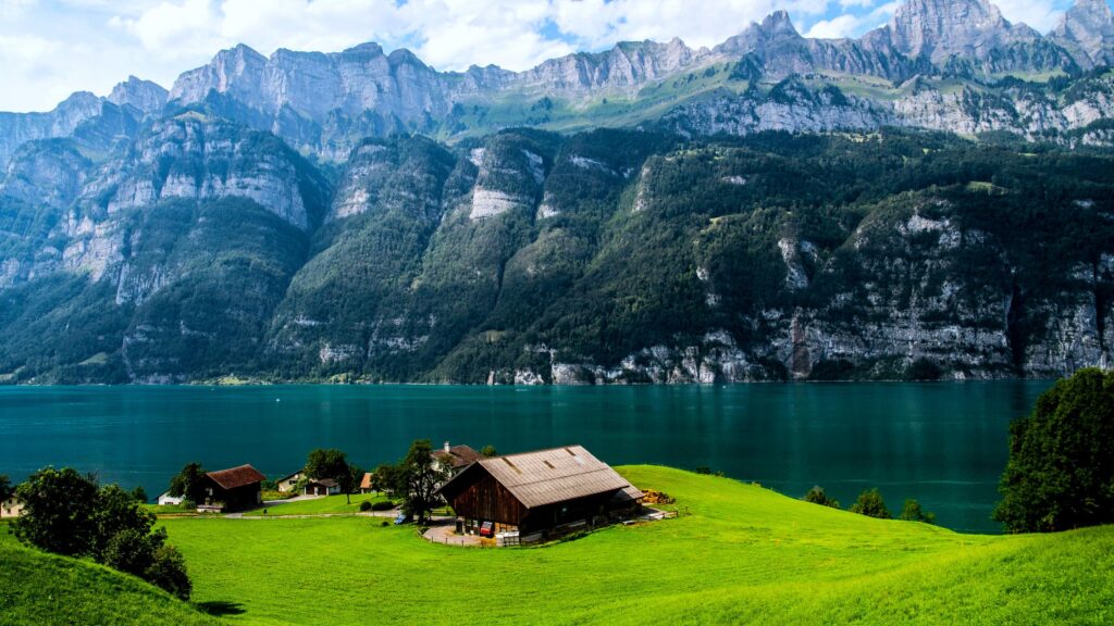 Stunning Alpine Lake House with Mountain Backdrop 4K Desktop Wallpaper