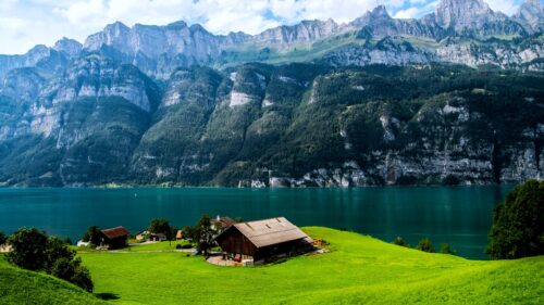 Stunning Alpine Lake House with Mountain Backdrop 4K Desktop Wallpaper